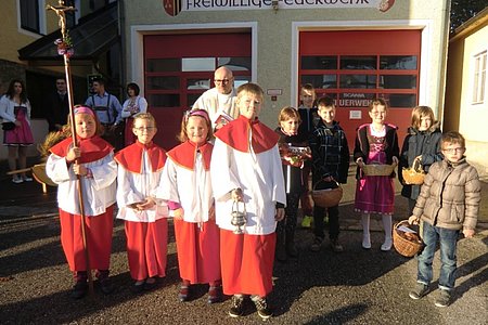 Pater Daniel Gärtner mit den Ministranten und den Erstkommunionkindern des Jahres 2014, die einen Korb mit Erntegaben mitgebracht haben.